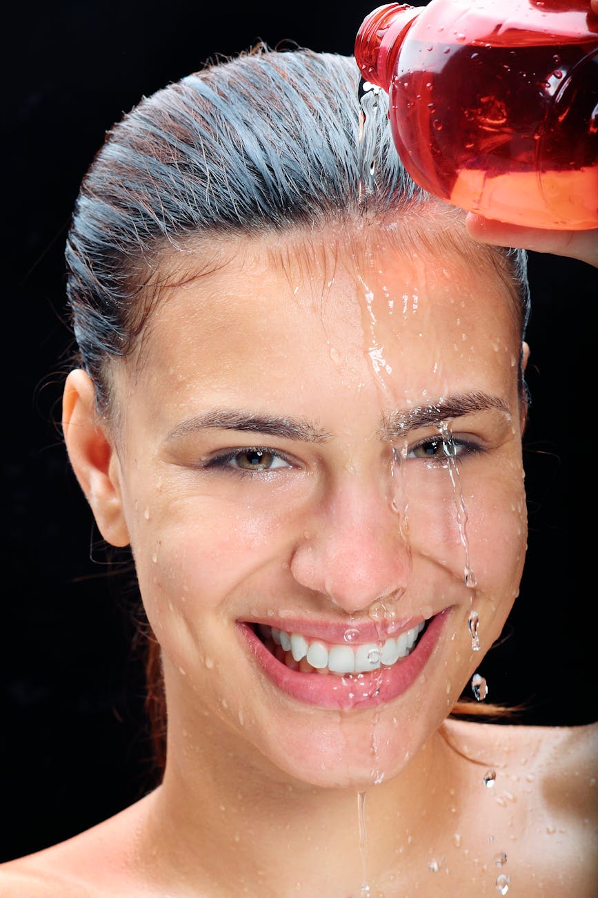 portrait of woman pouring water on face