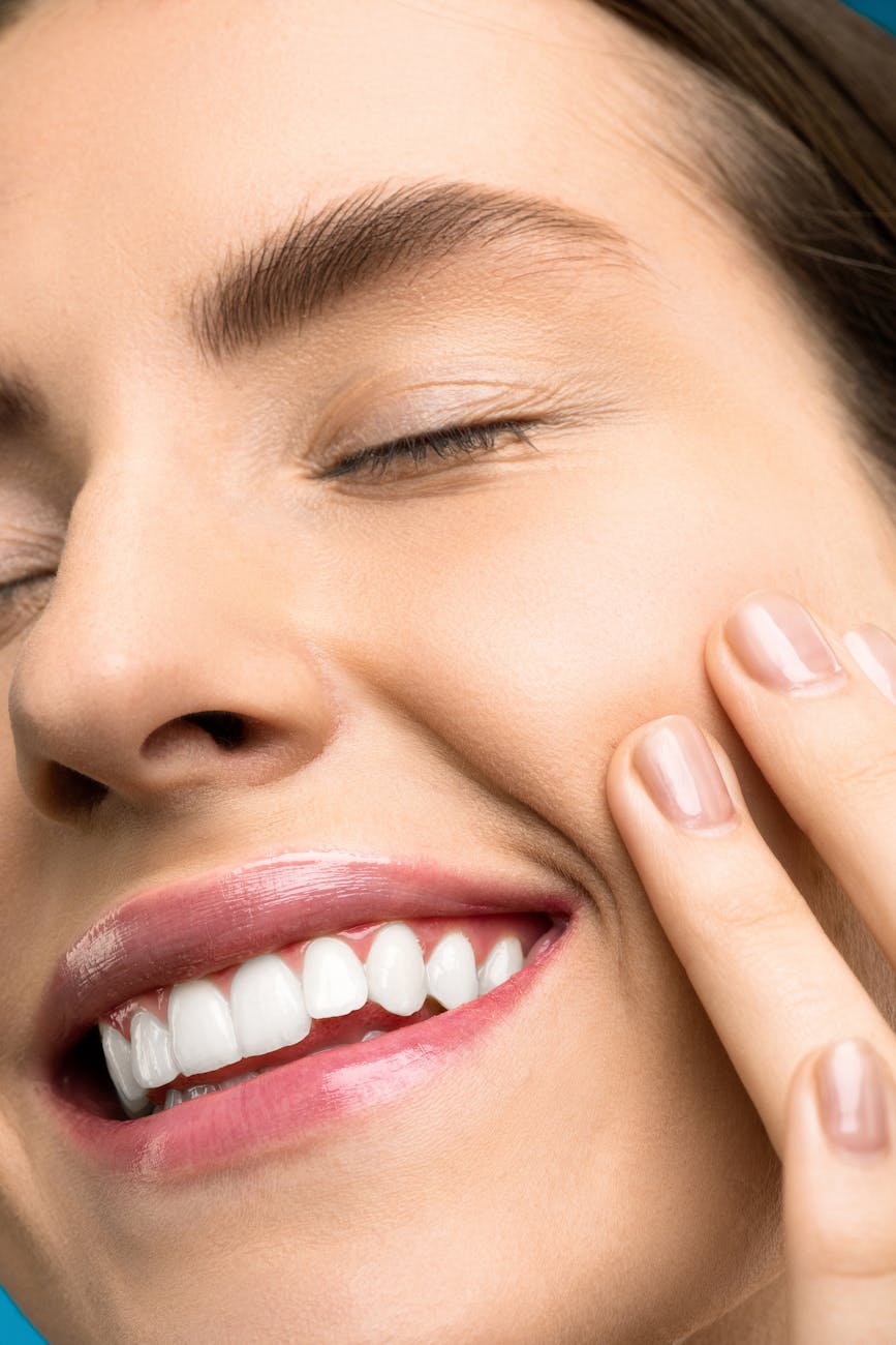 close up photo of woman with pink lipstick smiling with her eyes closed