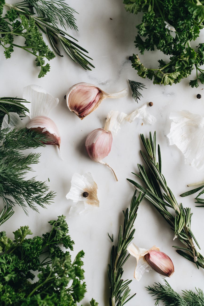 close up photo of garlic near herbs